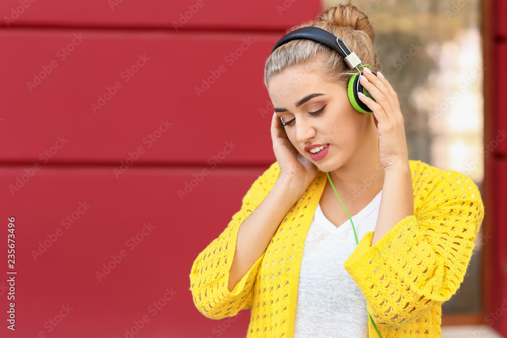 美丽的年轻女子在户外听音乐