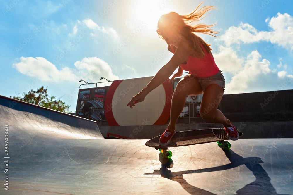 滑板手在行动。年轻女子在滑板公园玩冲浪滑板的黑色剪影