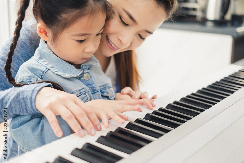 亚洲青年钢琴教师教女学生弹钢琴，音乐教育理念