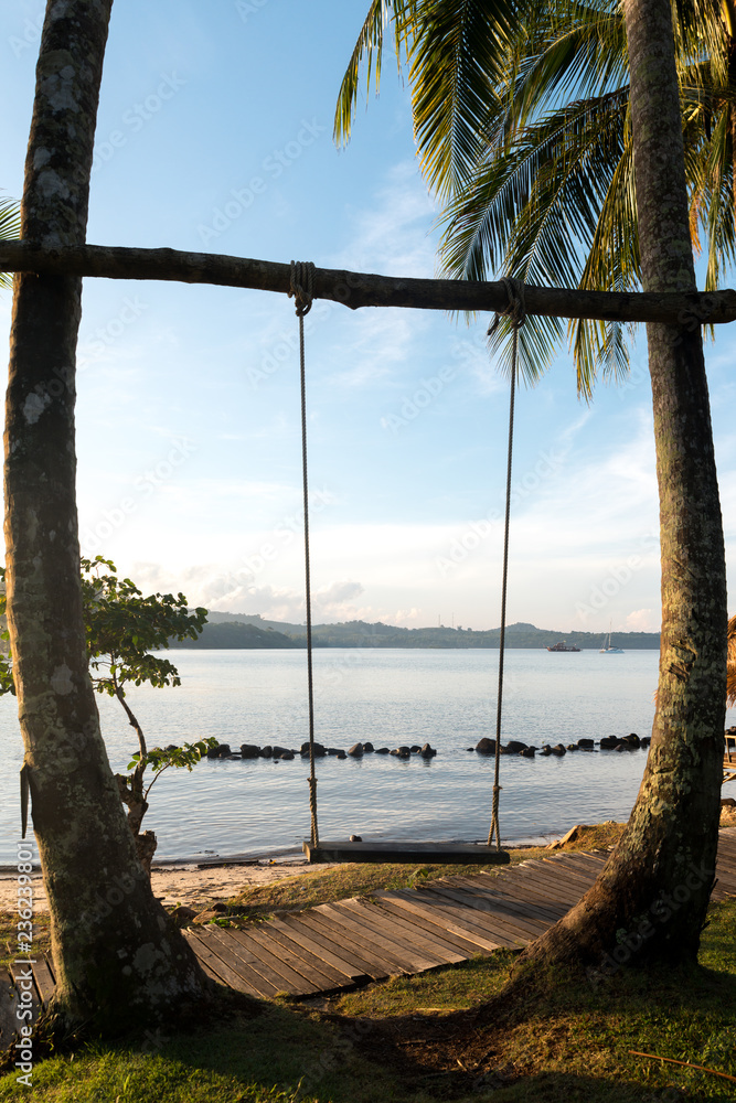 泰国普吉岛海滩附近的树上挂着木制秋千椅。暑假旅行