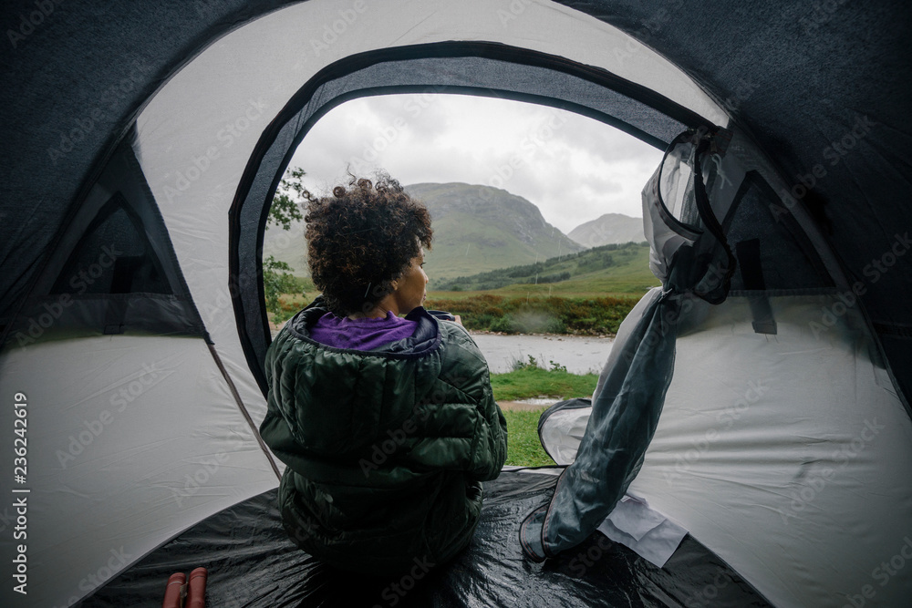 下雨时坐在帐篷里的女人