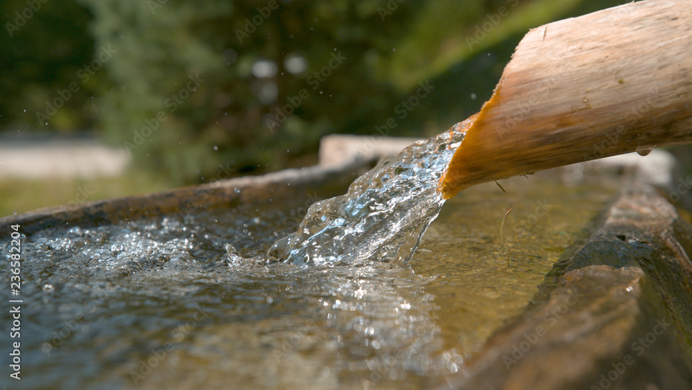 MACRO，DOF：清澈的溪水通过木管流入水池