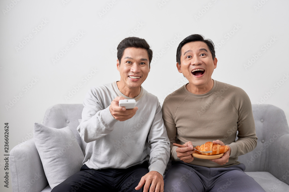 两个快乐的男人在家看电视喜剧电影，复制空间