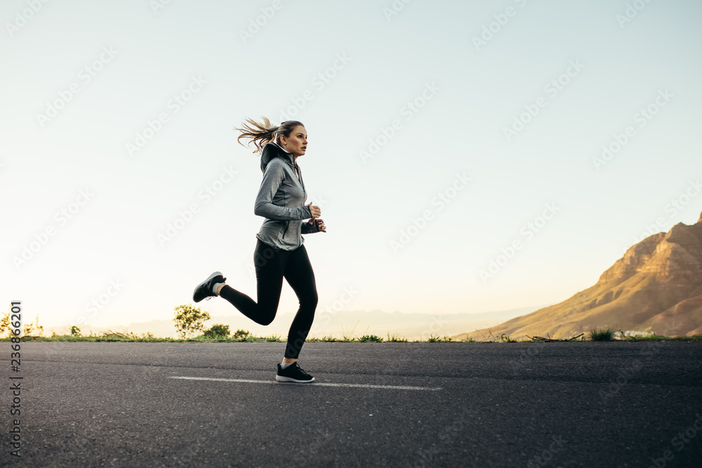 女运动员在公路上奔跑