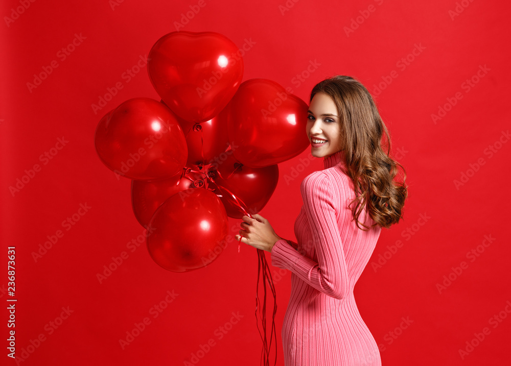 年轻美丽的感性女孩，身穿粉色连衣裙，红底红色气球。