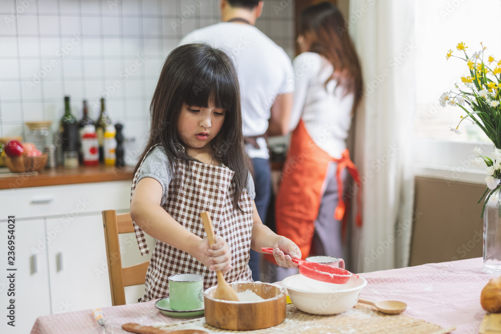 快乐的亚洲家庭在厨房烹饪，带着快乐和微笑，生活方式快乐的家庭理念