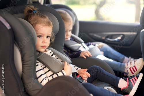 可爱的小双胞胎坐在汽车座椅上