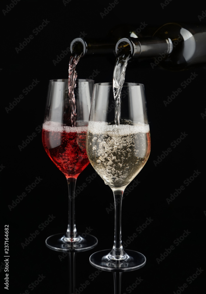 将白葡萄酒和红葡萄酒从瓶子里倒入深色背景的玻璃杯中