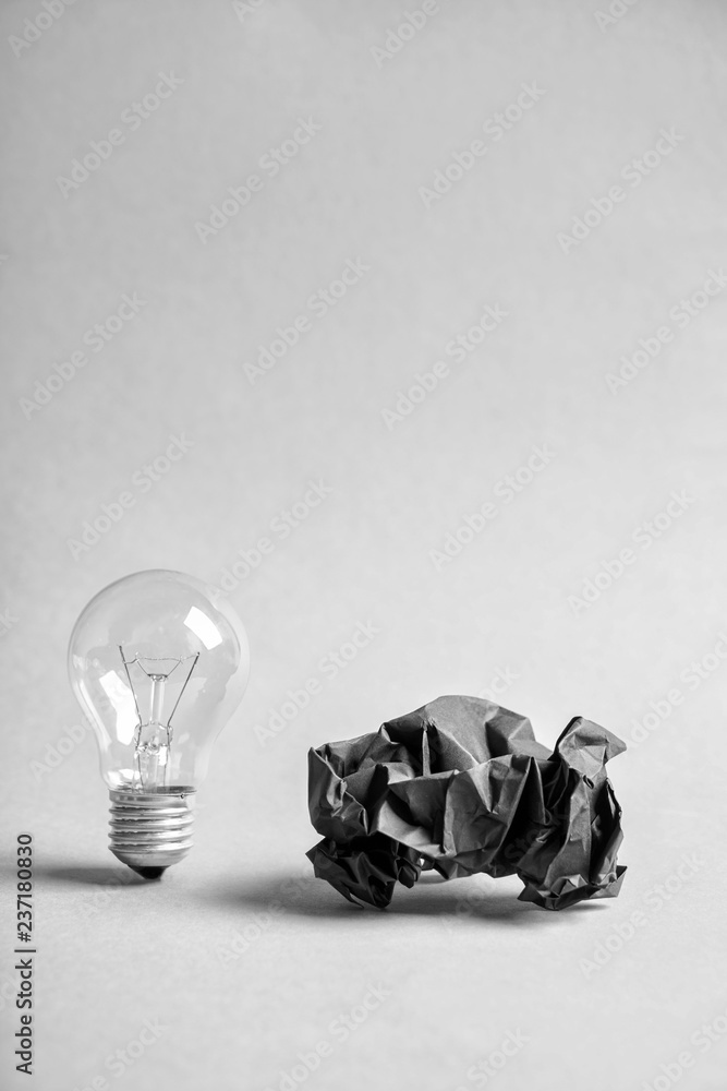 Light bulb with crumpled paper on white background
