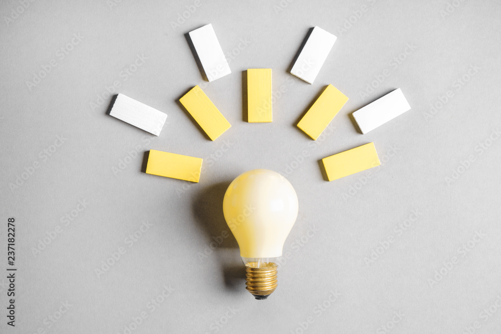 Creative composition with light bulb and color blocks on grey background