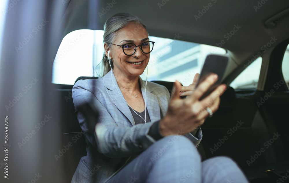 Business woman in car making a video call with smartphone