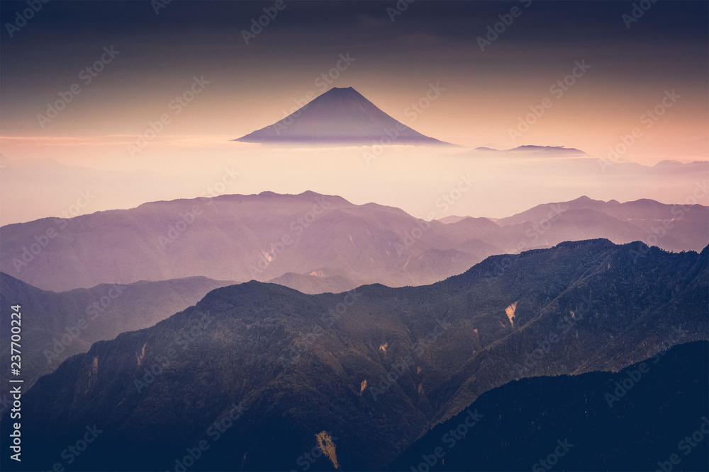 富士山在日出后的薄雾中与黄昏的天空一起从日本南阿尔卑斯山的北道出发