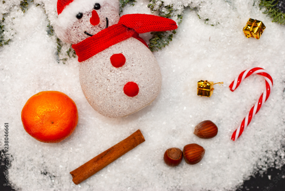 一个有小屋、围巾和一些冬季和圣诞节装饰的雪人