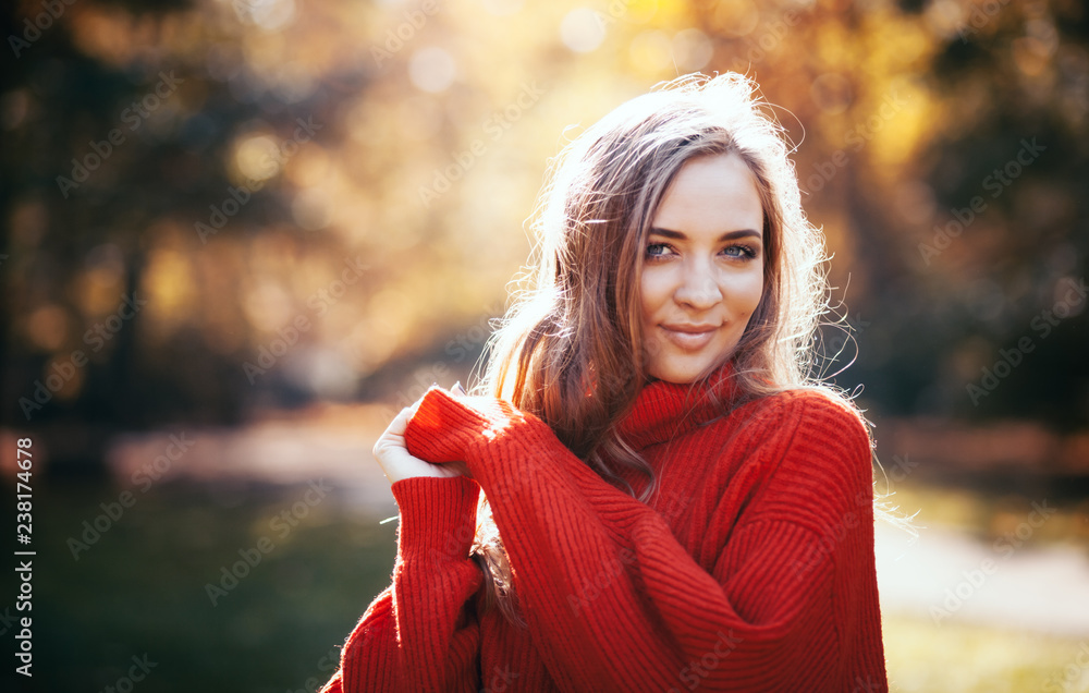 穿着柔软保暖针织毛衣的自然年轻女性在户外行走，秋天和春天