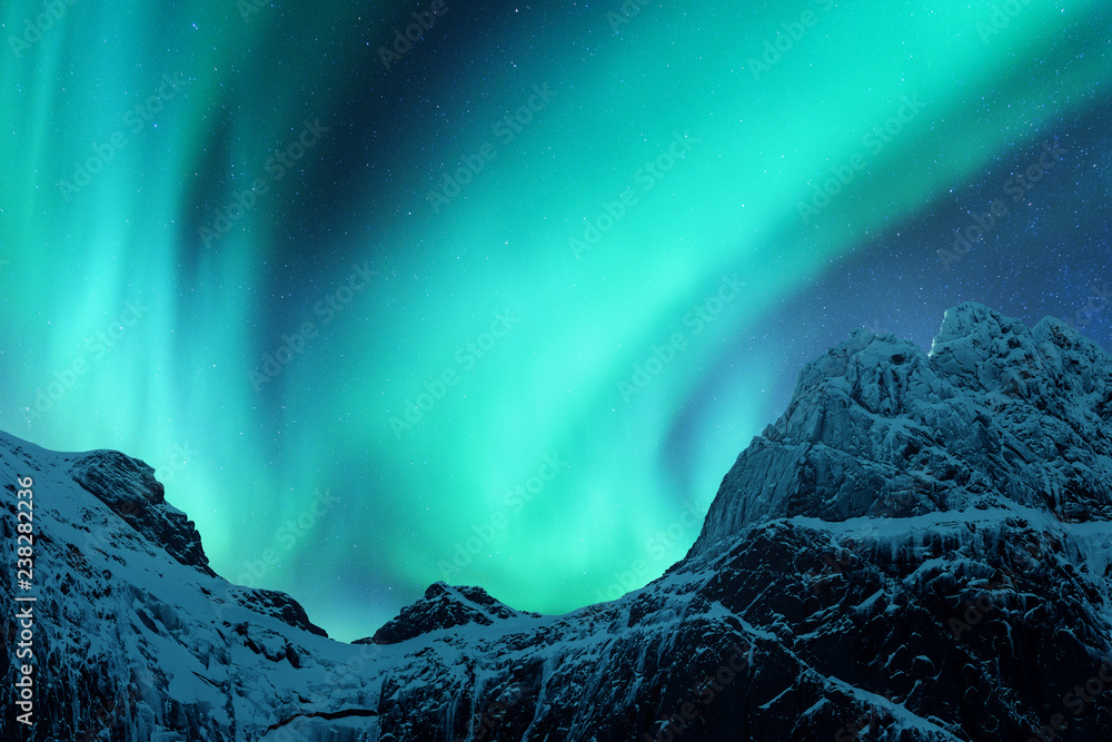 北极光在挪威罗弗敦群岛白雪皑皑的山峰上。北极光在
