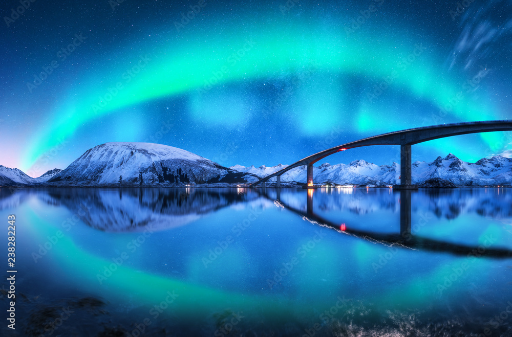 雪山上的桥和北极光。挪威罗弗敦群岛。令人惊叹的北极光。