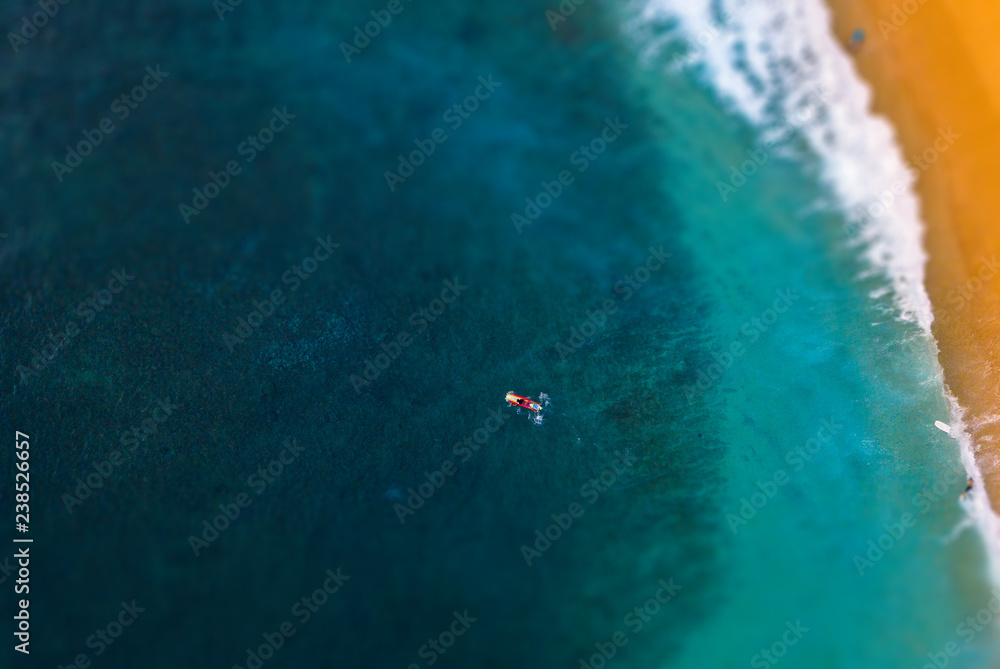 黄沙海湾中长板冲浪者的鸟瞰图。应用了倾斜偏移效果