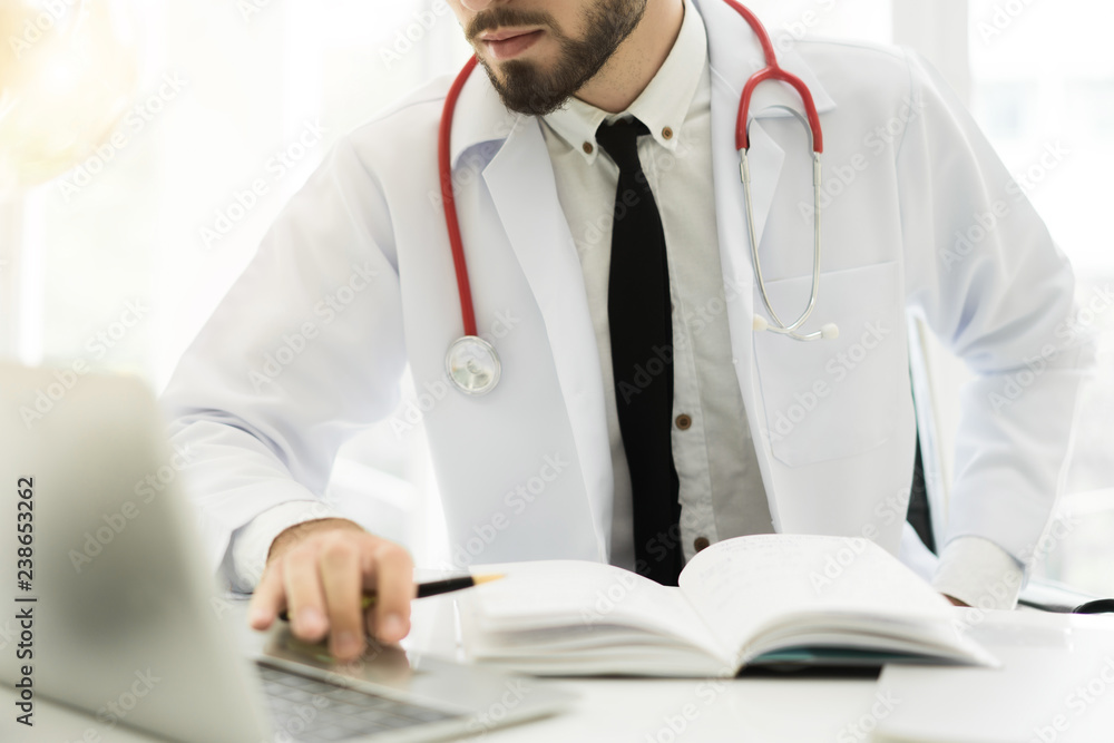 医生使用笔记本电脑和电子病历（EMR）系统。患者健康数字数据库