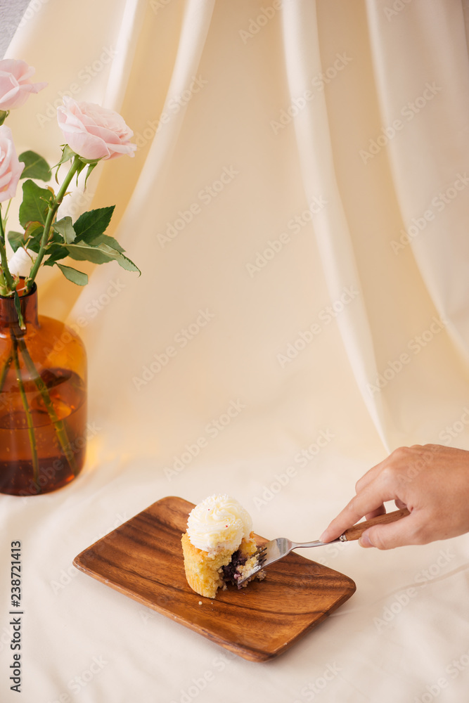 女性手切桌上美味的纸杯蛋糕
