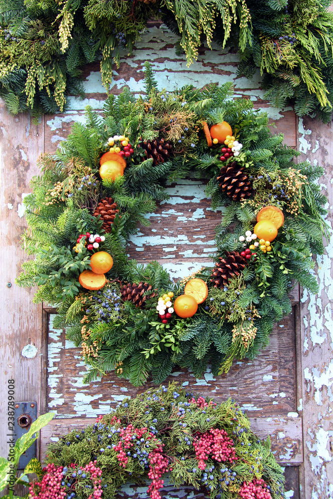 Fresh Christmas wreath made of cedar boughs, oranges and pinecones. 