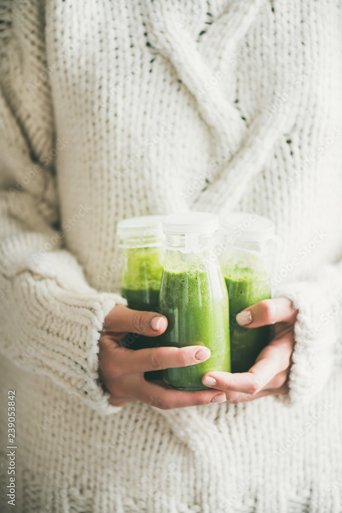 女性手中的健康绿色奶昔或瓶装果汁