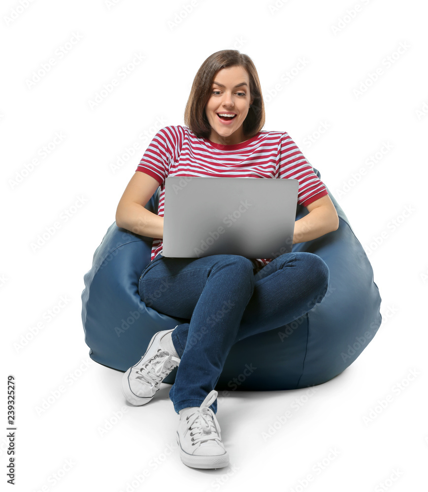 拿着笔记本电脑的年轻女子坐在白色背景下的豆袋椅上