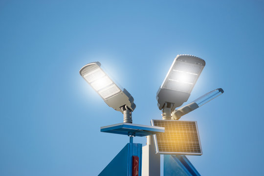 太阳能板与灯在蓝天下的能源动力概念。