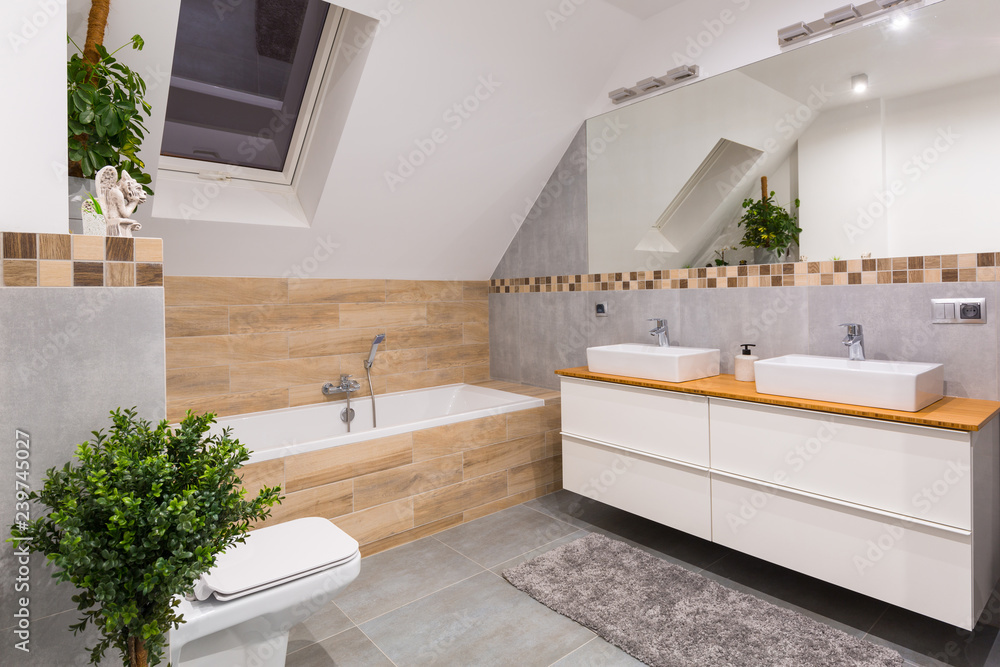 灰色瓷砖和木质装饰的现代浴室内部