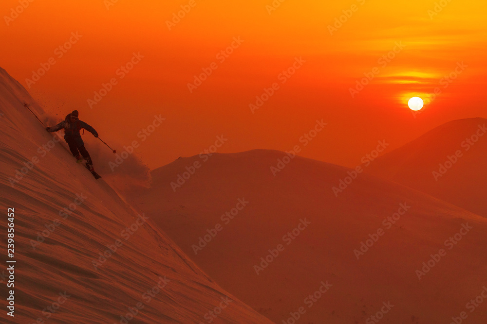 雪道：专业滑雪者在一个阳光明媚的夜晚骑行离开雪道的壮观镜头。