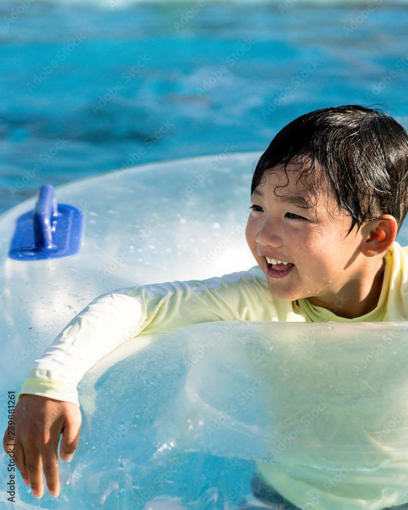 微笑的男孩在游泳池溅水
