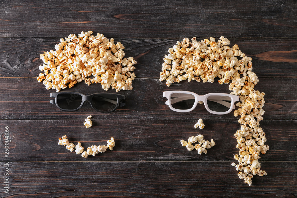 Funny couple made of popcorn on dark wooden background