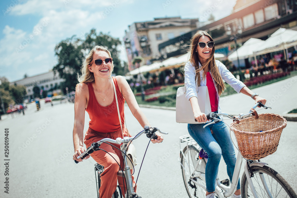 两位美女在城市骑自行车购物