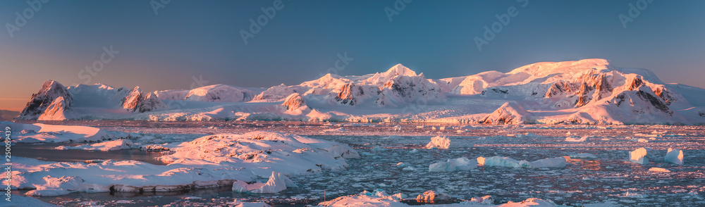 南极洲海岸线的粉红色山脉全景。令人惊叹的全景。冰漂浮物的碎片