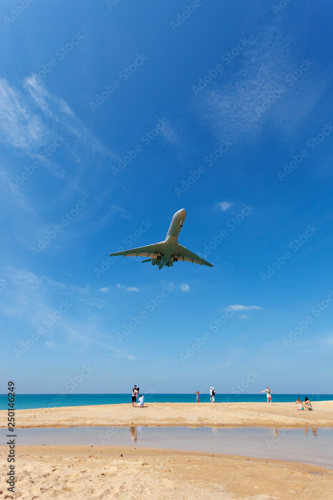 Commercial airplane landing above sea and clear blue sky over beautiful scenery nature background lo