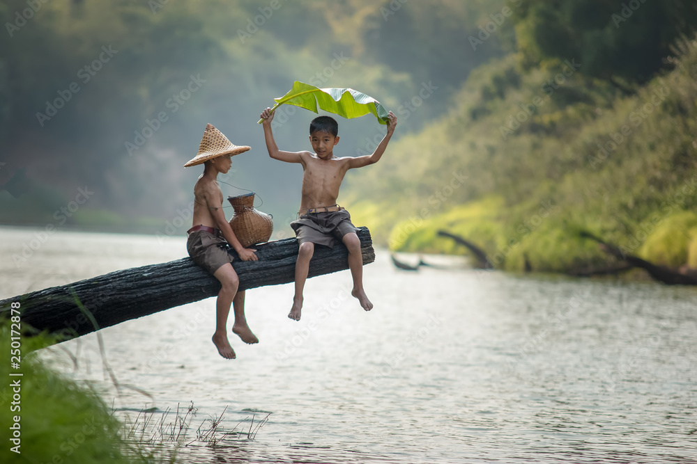 生活在越南农村的贫困儿童在河边钓鱼，亚洲的农村概念