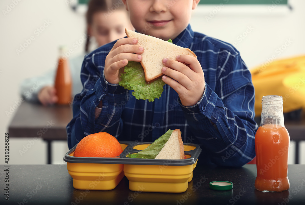 小男孩在教室里吃学校午餐
