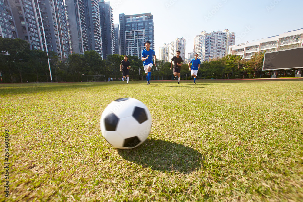亚洲足球运动员追逐球