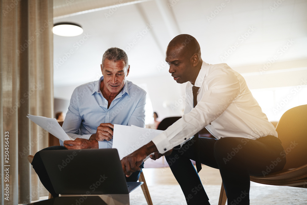 不同的商人在办公室用笔记本电脑讨论工作
