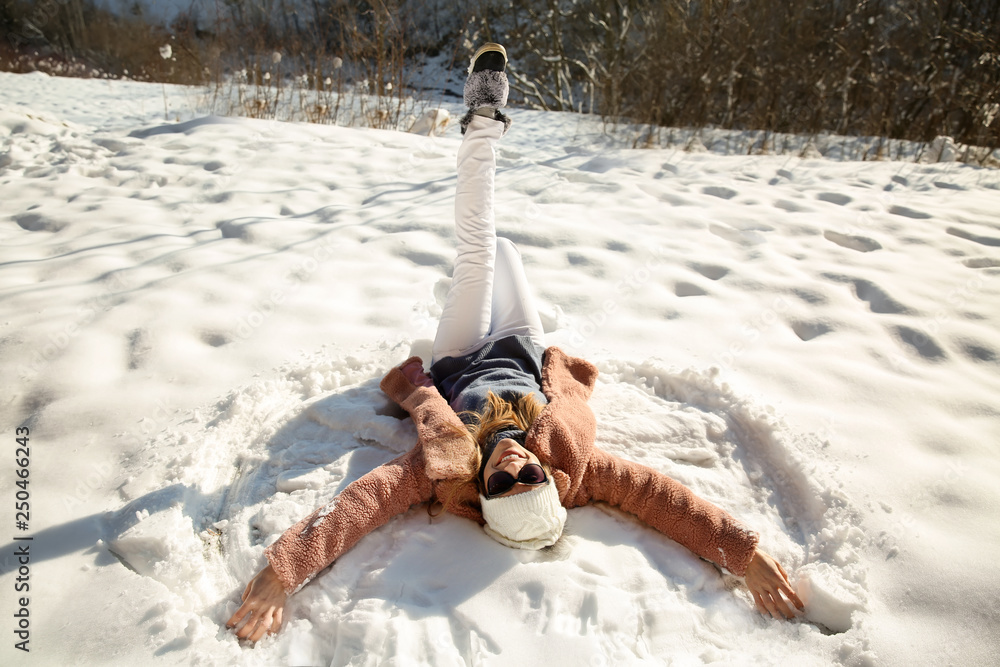Happy woman lying on snow