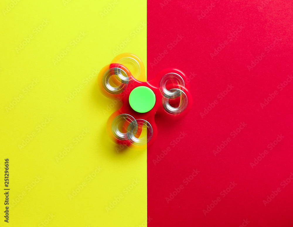 Stroboscopic photo of moving spinner on color background