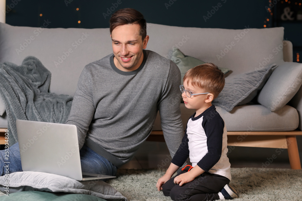 年轻的父亲带着小儿子在家看动画片