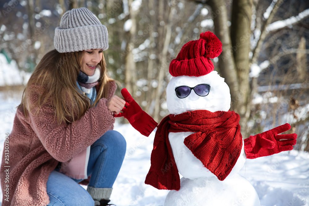 冬日快乐的女人和有趣的雪人