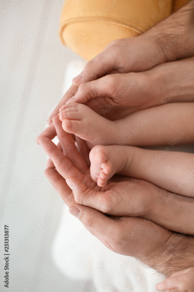 父母在家抱着可爱的小婴儿的脚