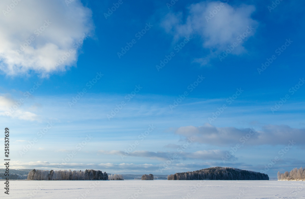 芬兰一个寒冷的冬天早晨，湖面上的冬季仙境。蓝天和日出