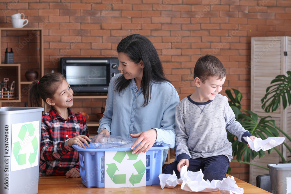 Family sorting garbage at home. Concept of recycling