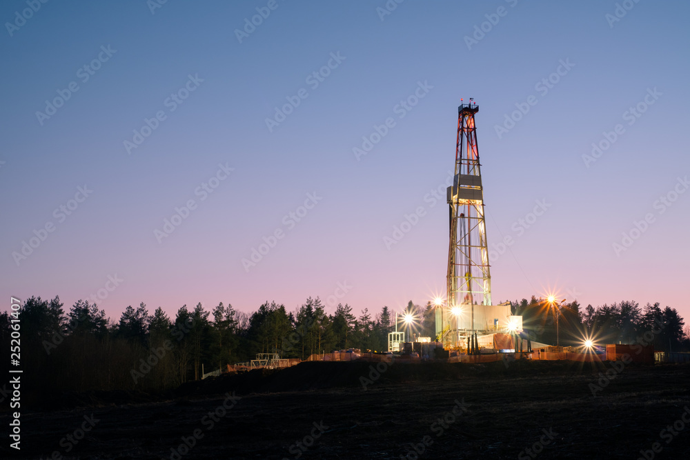 Oil gas drilling rig on sunset background. Industrial concept