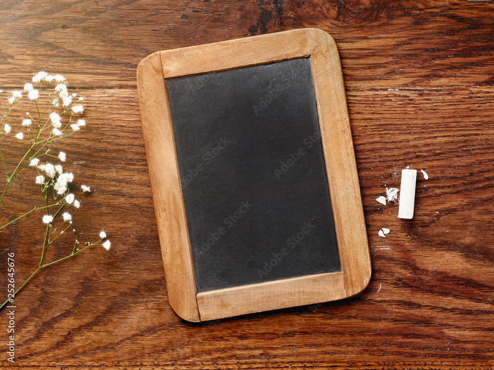 Chalk board and chalk on wooden table. Mockup for calligraphy and lettering.