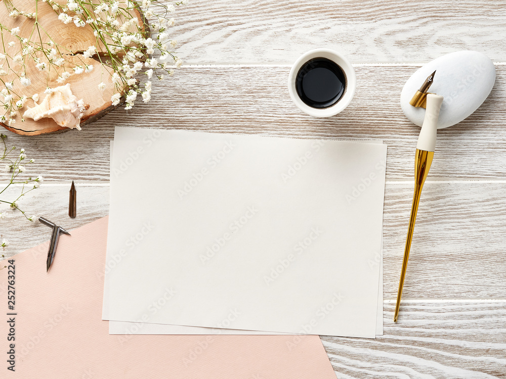 用书法笔在白色木背景上制作邀请函或信件的空白纸模型