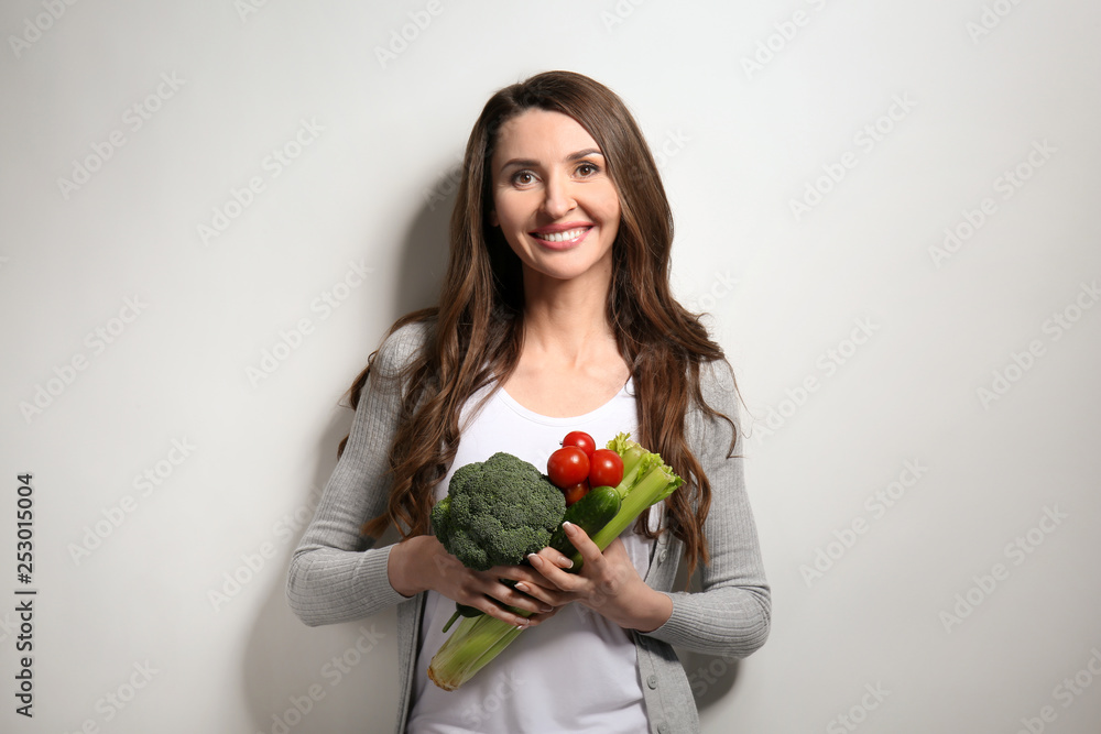 浅色背景下有新鲜蔬菜的女人