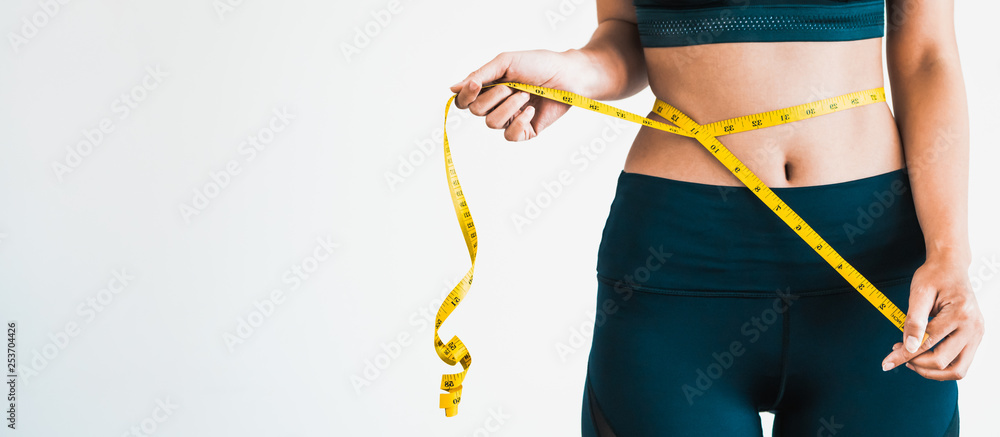 身材苗条的女性测量腰围和躯干的特写镜头。健康的营养和体重